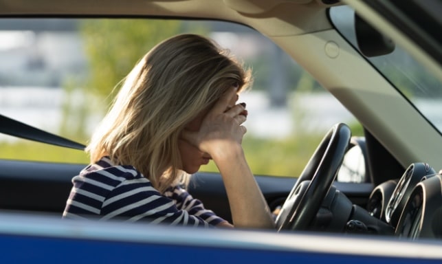 Woman experiencing driving anxiety sitting behind the wheel | Daniel Stark Injury Lawyers