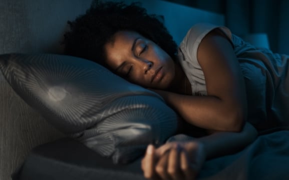 Woman sleeping peacefully in bed to support injury recovery | Daniel Stark Injury Lawyers