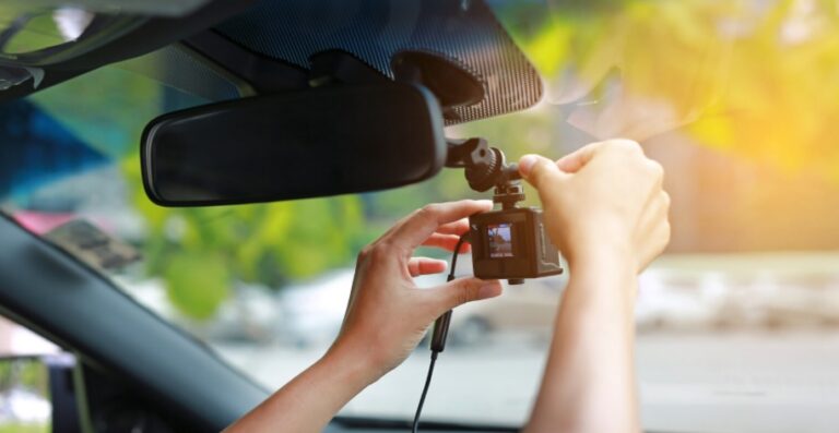 Person installing a dashcam for cars on their windshield | Daniel Stark Injury Lawyers