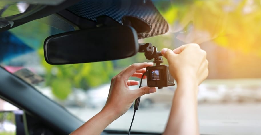 Person installing a dashcam for cars on their windshield | Daniel Stark Injury Lawyers