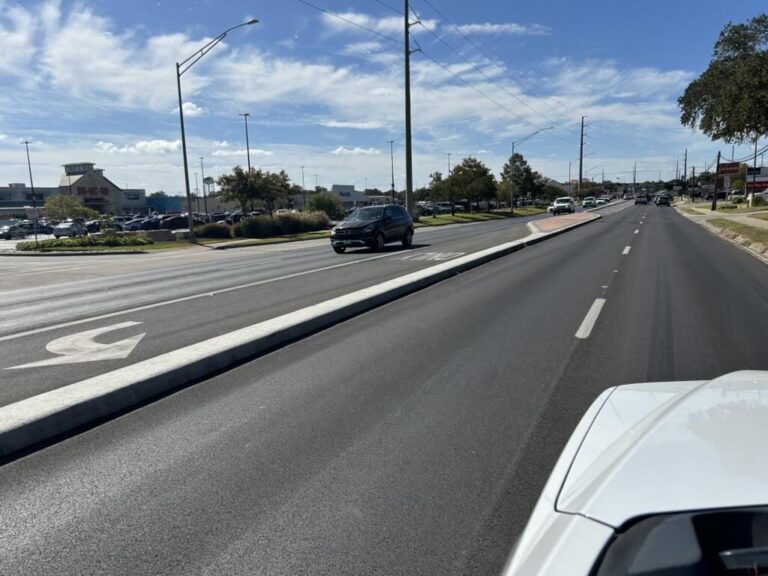 Vehicles traveling along a Bryan, Texas roadway divided by a raised concrete median | Daniel Stark Injury Lawyers