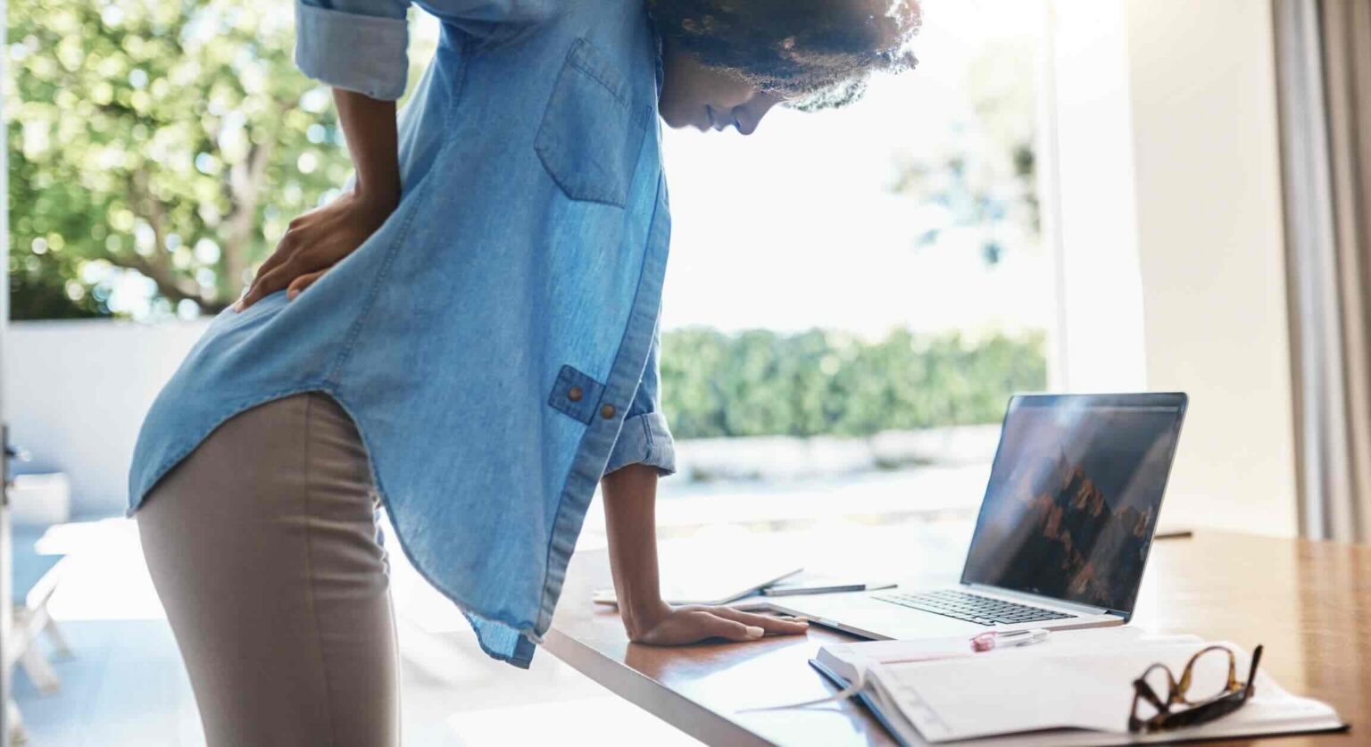 Female remote employee suffering lower back injury, work-from-home injury | Daniel Stark Injury Lawyers