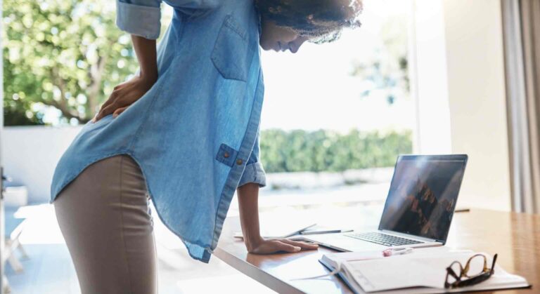 Female remote employee suffering lower back injury, work-from-home injury | Daniel Stark Injury Lawyers