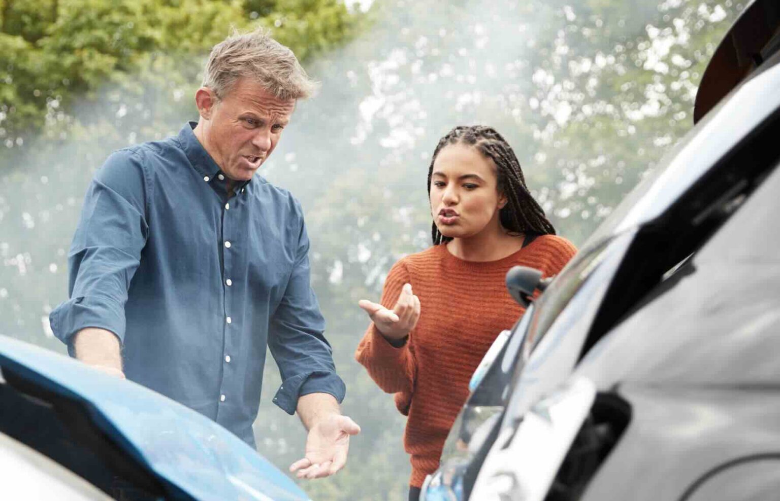 A man and woman arguing in front of the scene of a car accident trying to figure out fault | Daniel Stark Injury Lawyers