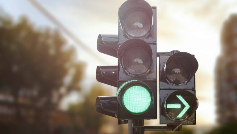 Photo of a traffic light and an advanced green arrow to illustrate the right of way in driving | Daniel Stark Injury Lawyers