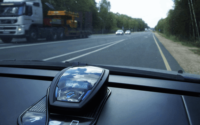 A police radar detector on the dash of a car driving down a country road | Daniel Stark Law