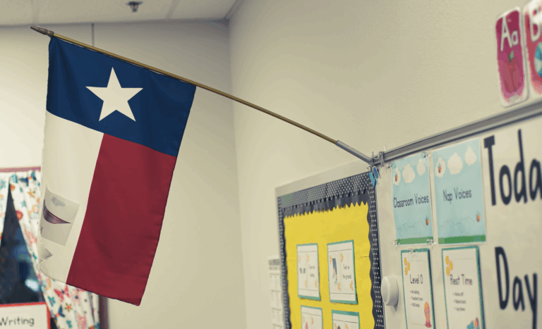 A photo of a classroom whiteboard with a texas flag mounted on the frame | Daniel Stark Law.