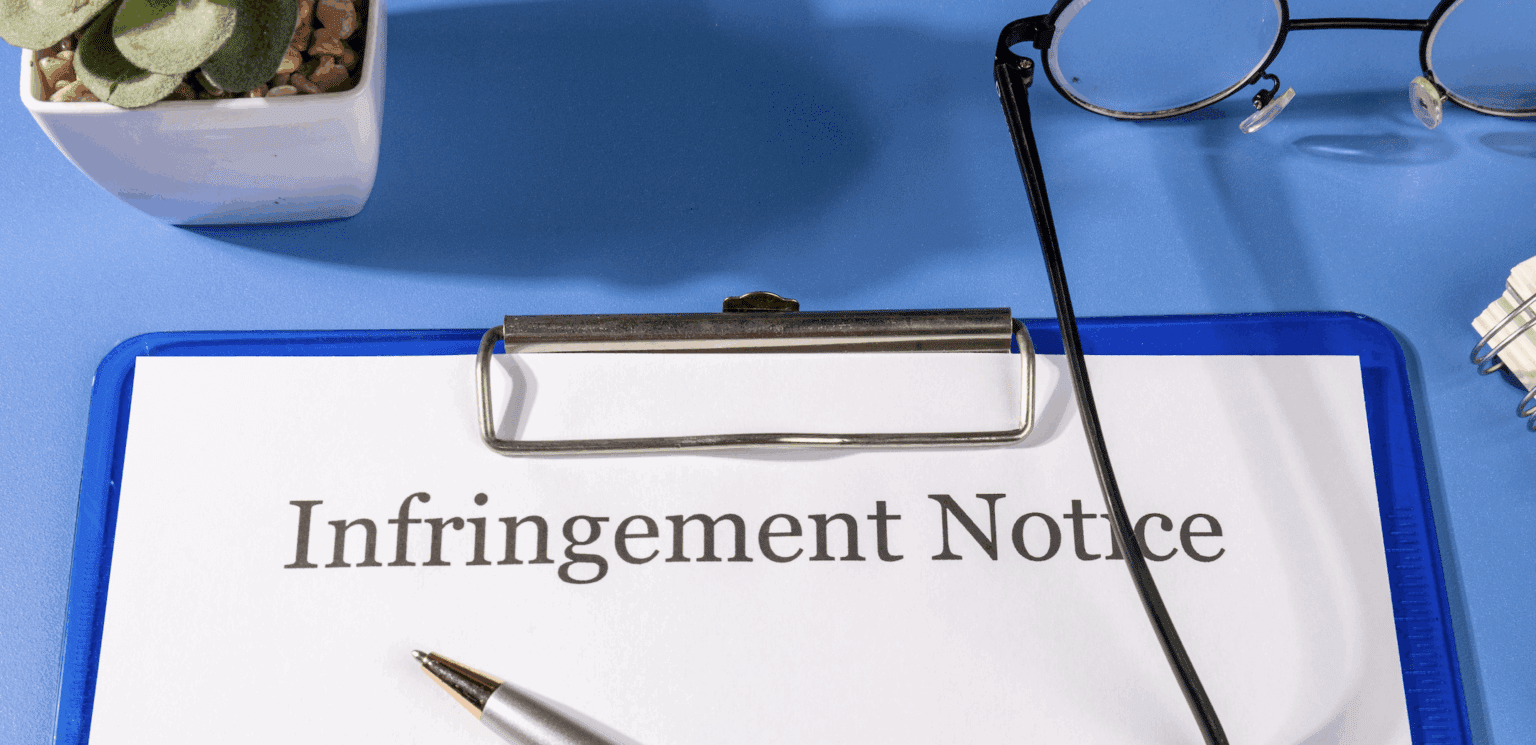 blue clipboard on desk with Intellectual Property Infringement Notice | Daniel Stark Law