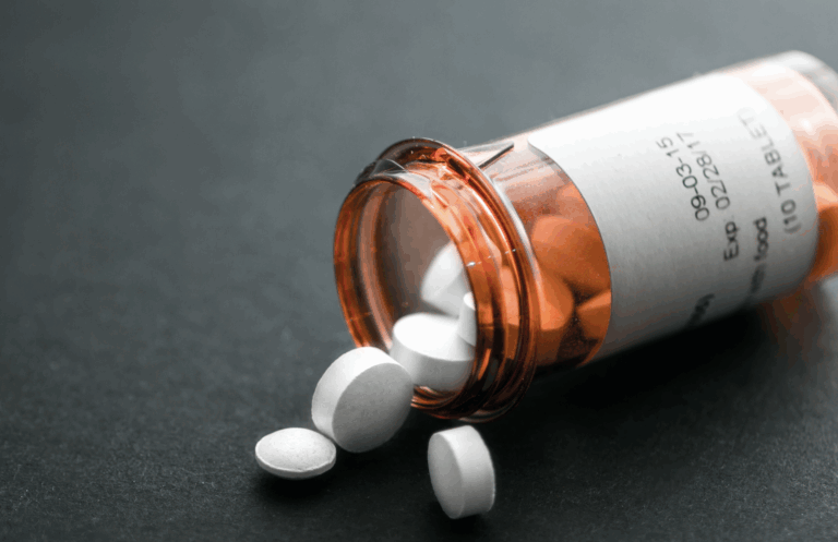 A photo of a bottle of prescription pills spilling out on a table | Daniel Stark Law