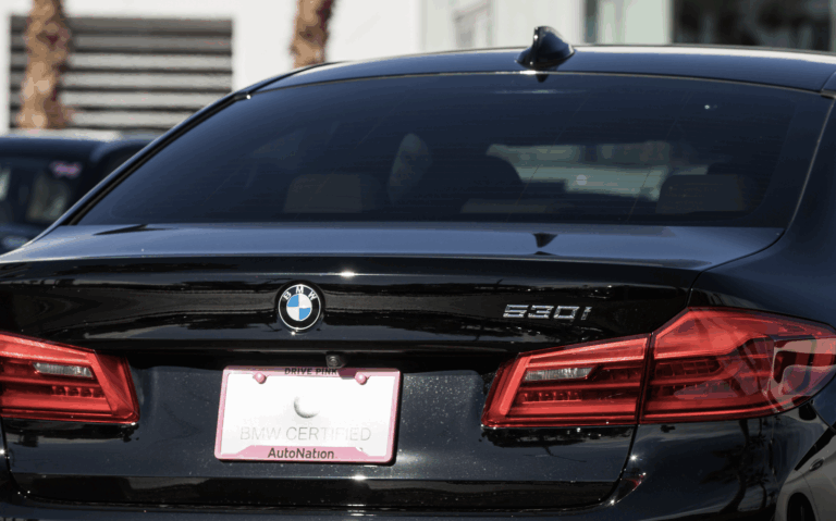 Black car with decorative pink AutoNation license plate frame | Daniel Stark Law