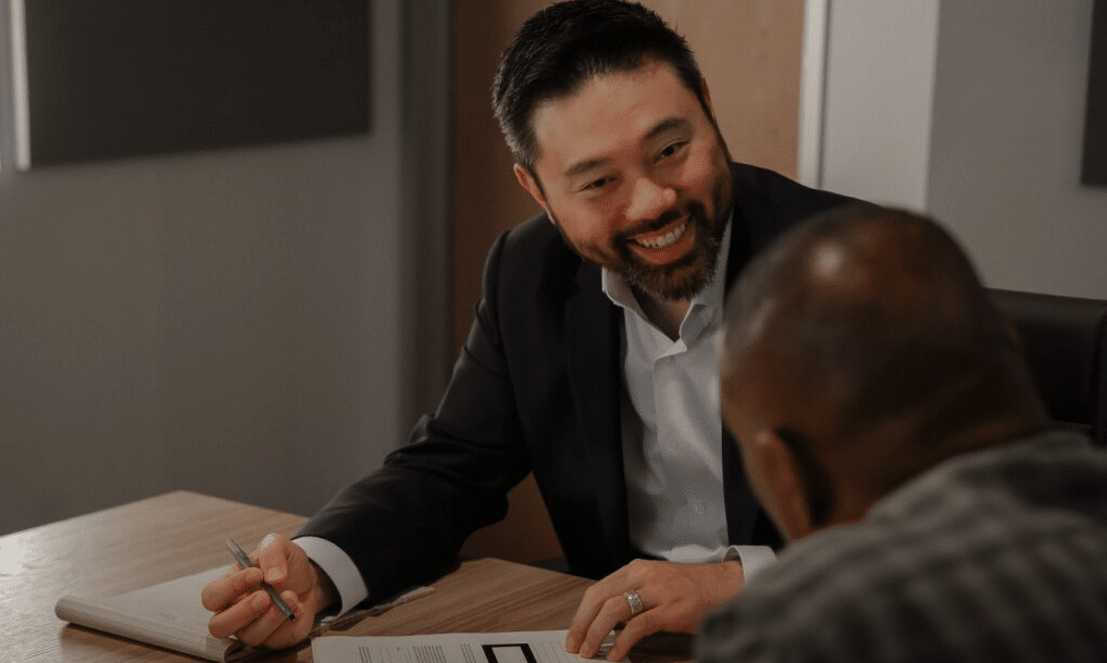 Michael Loh, partner at Daniel Stark Injury Lawyers, discussing case details with a client in the conference room | Daniel Stark Injury Lawyers