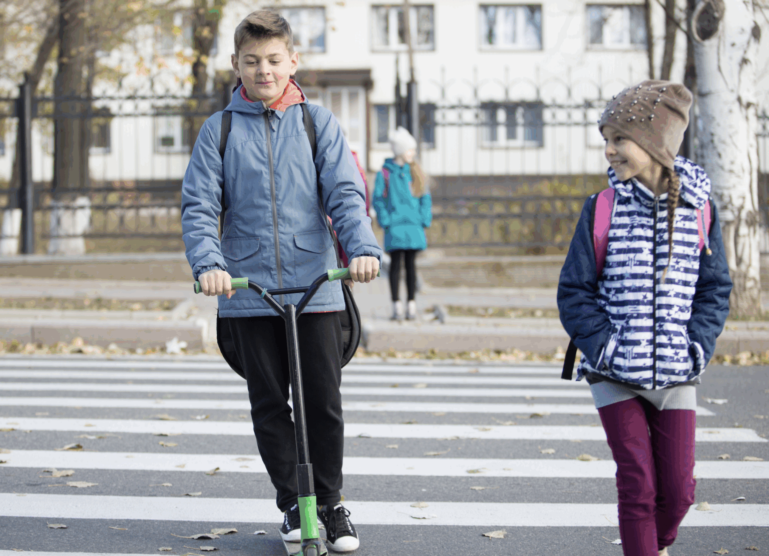 Young boy on a scooter and girl walking through a school zone crosswalk | Daniel Stark Injury Lawyers