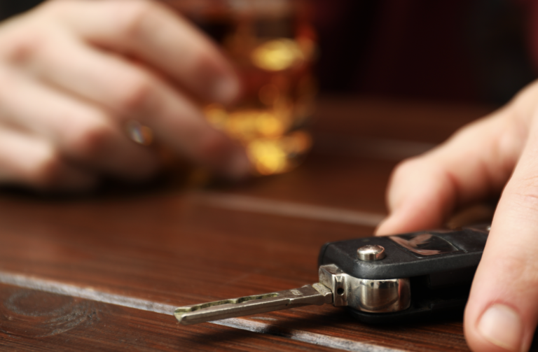 Man showing visible signs of intoxication reaching for car keys at a bar | Daniel Stark Injury Lawyers