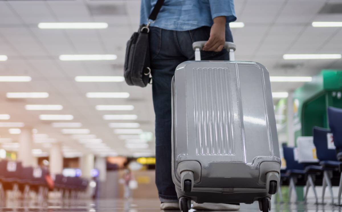 Passenger moving through an airport with a wheeled suitcase | Daniel Stark Injury Lawyers