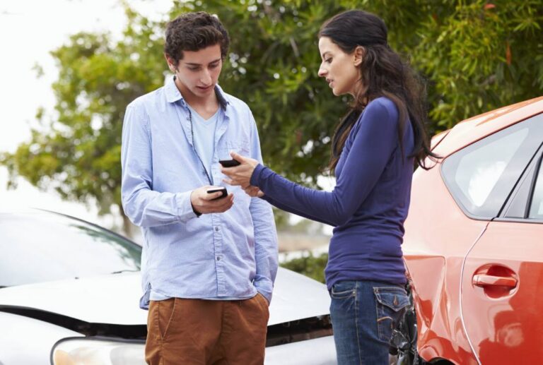 Man and woman exchanging insurance information after a rear-end car accident | Daniel Stark Injury Lawyers