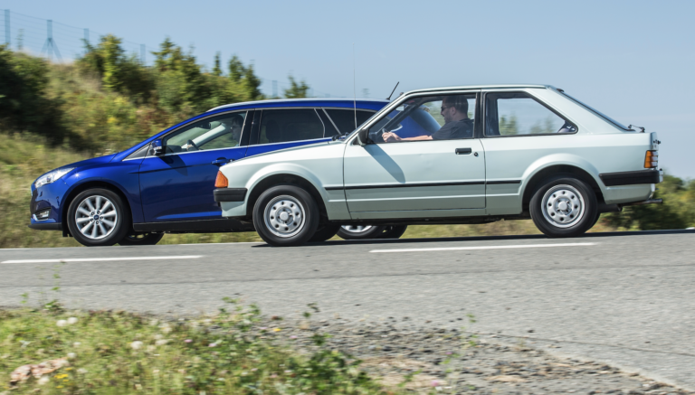 Comparison of an older silver car and a modern blue car driving side by side | Daniel Stark Injury Lawyers