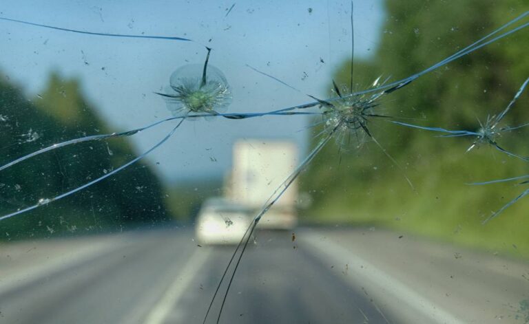 Interior vehicle view showing a cracked windshield obstructing the driver’s line of sight, with traffic ahead out of focus | Daniel Stark Injury Lawyers