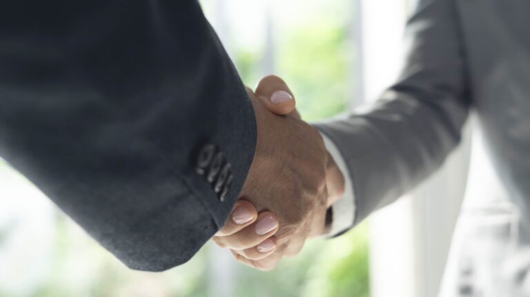 Two professionals shaking hands after reaching a settlement agreement | Daniel Stark Injury Lawyers