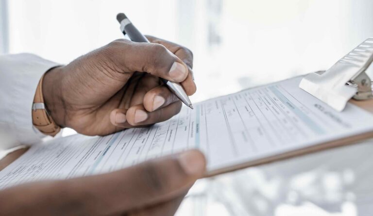 Close-up of physician completing medical records after car crash injury | Daniel Stark Injury Lawyers