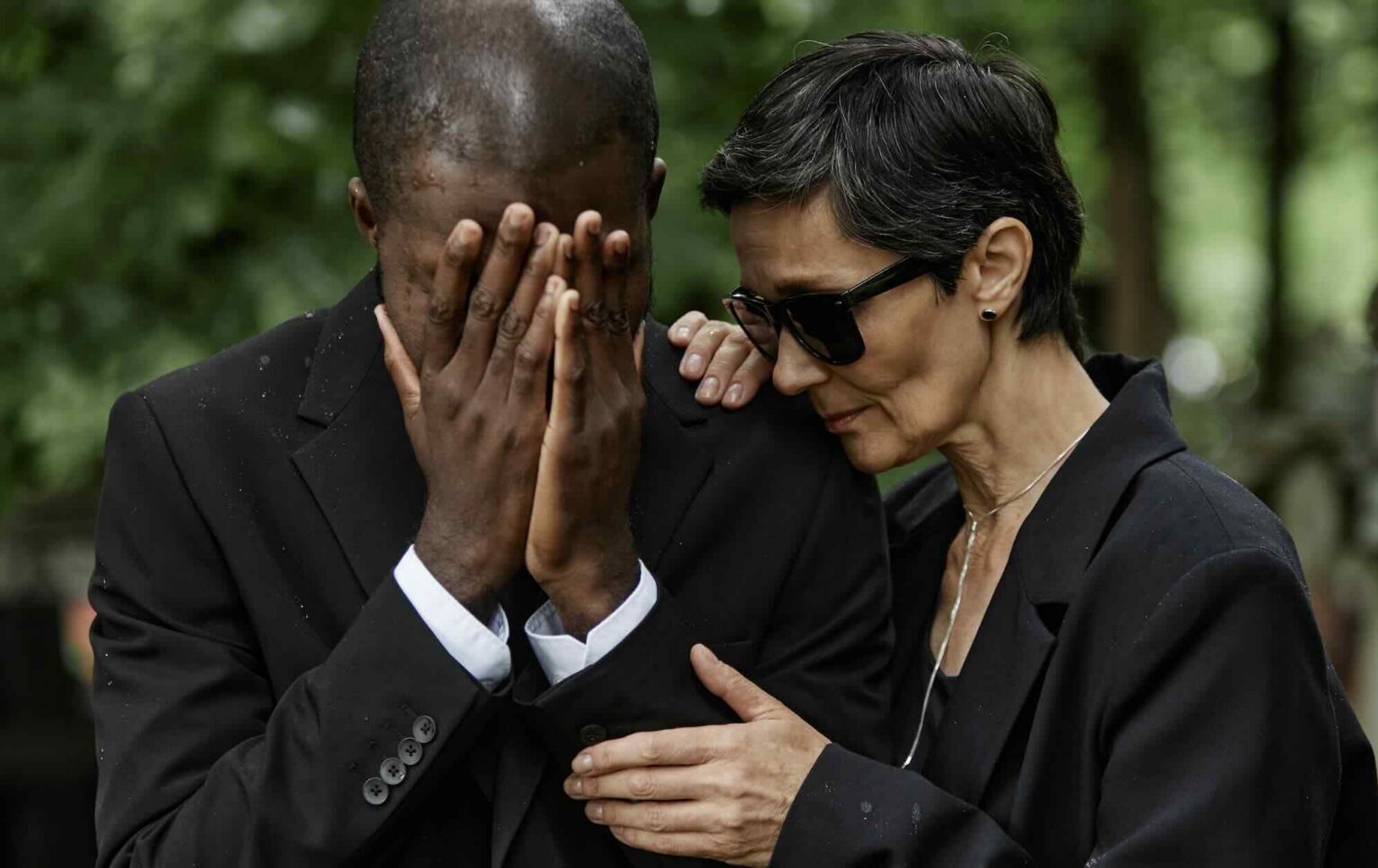 Family member consoling grieving man at funeral service | Daniel Stark Injury Lawyers