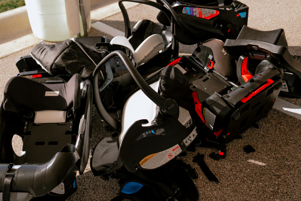 Discarded child safety seats collected after being replaced with new, properly fitted car seats during the Georgetown car seat safety event | Daniel Stark Injury Lawyers